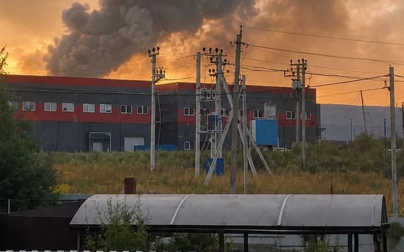 Пожежа та стовп диму над складським приміщенням після удару безпілотника